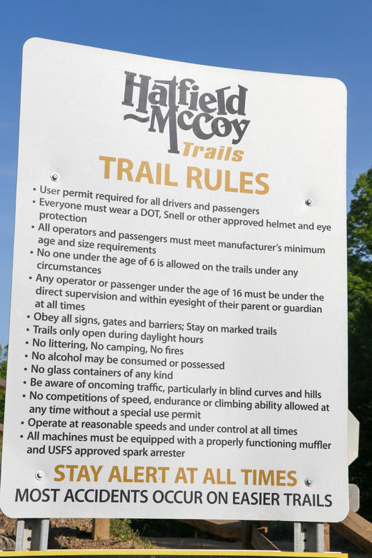 Hatfield-McCoy Trails official rules sign listing safety, permit, and machine regulations for West Virginia off-roading.