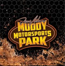Dennis Anderson’s Muddy Motorsports Park logo featuring a stylized off-road tire tread background with orange and yellow "Muddy Motorsports Park" text.