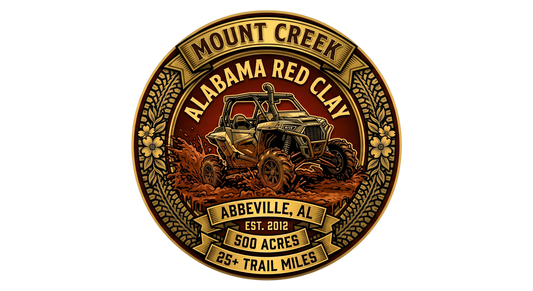 Off‑road logo for Mount Creek Alabama Red Clay in Abbeville, featuring a mud‑splattered ATV driving through deep red clay inside a gold floral emblem with details noting 500 acres, 25+ trail miles, and est. 2012.